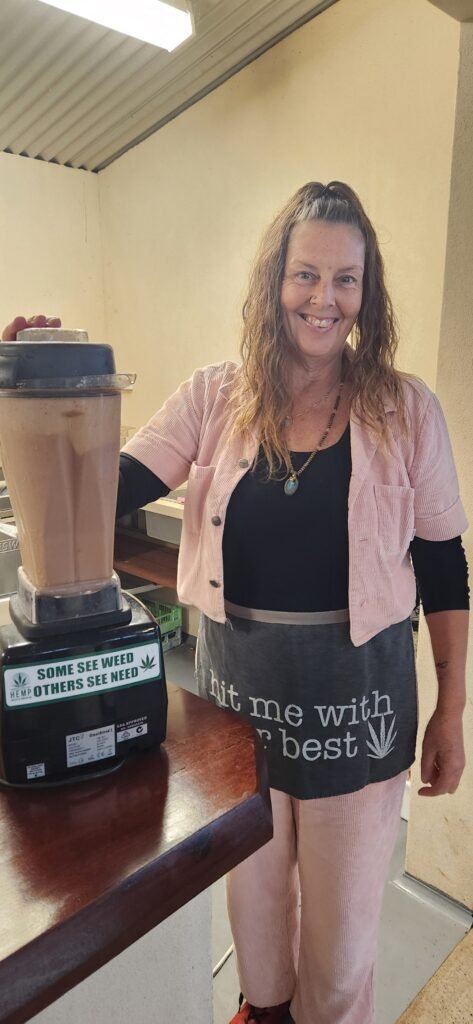 A woman standing next to a blender