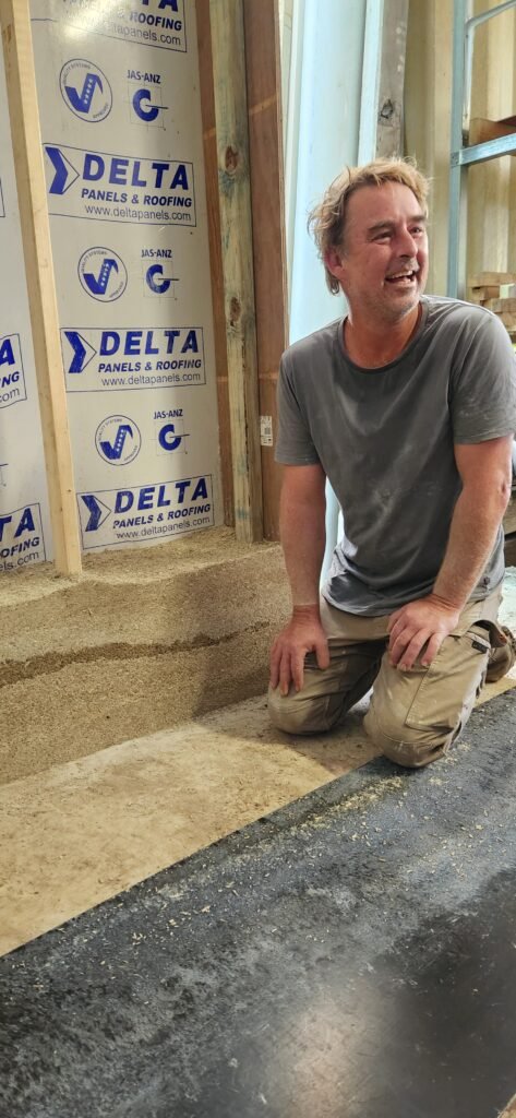 Man kneeling next to the start of a new hemp wall