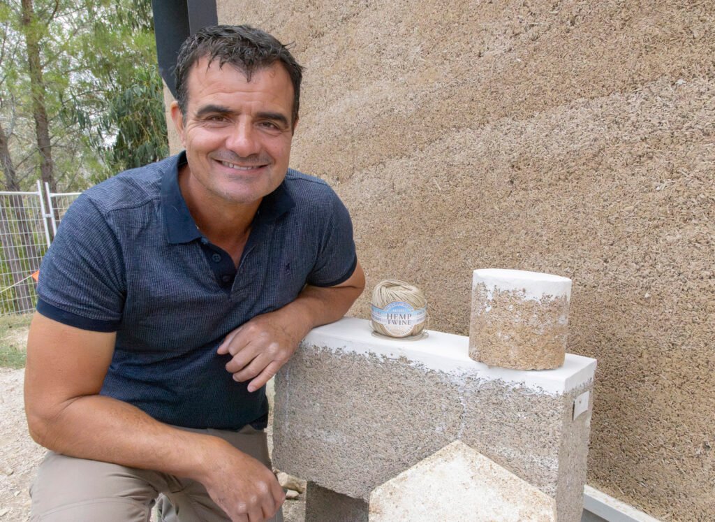 Close up of man with his elbow on a hemp brick next to a hemp wall